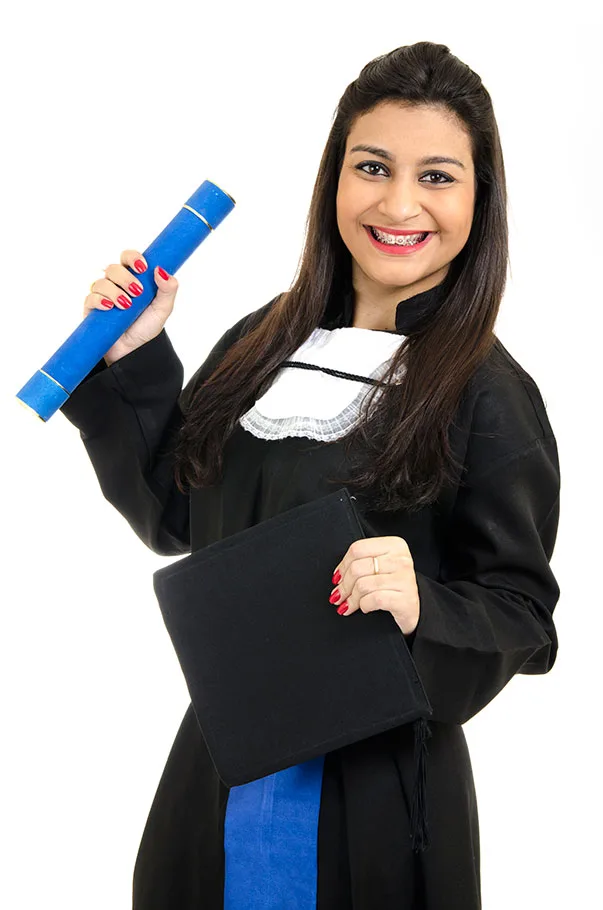 Formanda de beca segurando um canudo azul em retrato de estúdio